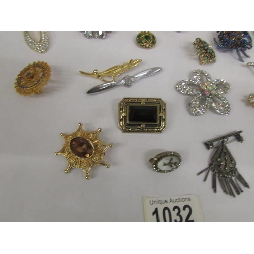 1032 - A good mixed lot of brooches, scarf clips and pendants.