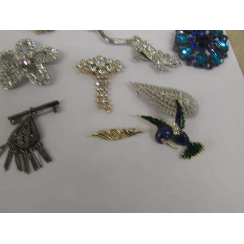 1032 - A good mixed lot of brooches, scarf clips and pendants.