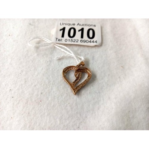 1010 - A yellow gold double heart diamond pendant, 1.8 grams.