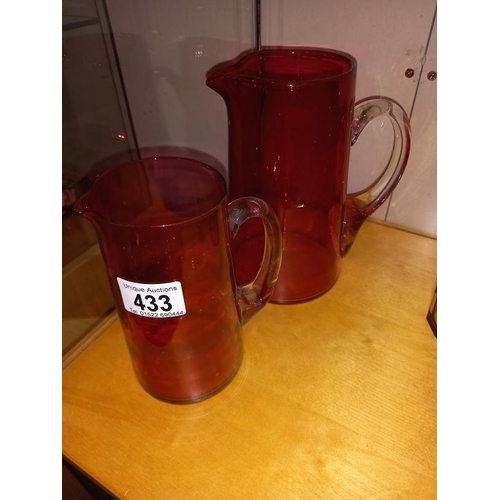 433 - 2 Cranberry glass jugs and 2 bohemian lidded glass jars.