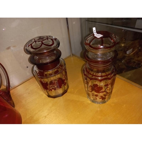 433 - 2 Cranberry glass jugs and 2 bohemian lidded glass jars.