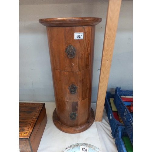 507 - A round teak 3 drawer chest. Height 61cm, top diameter 29 cm. Collect Only.