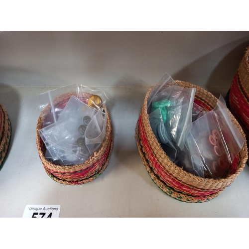 574 - A good selection of vintage buttons in graduated wicker lidded baskets.