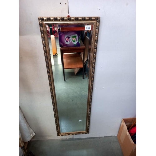 569 - A gilt framed bevelled edge mirror. 37cm x 124cm. Collect Only.