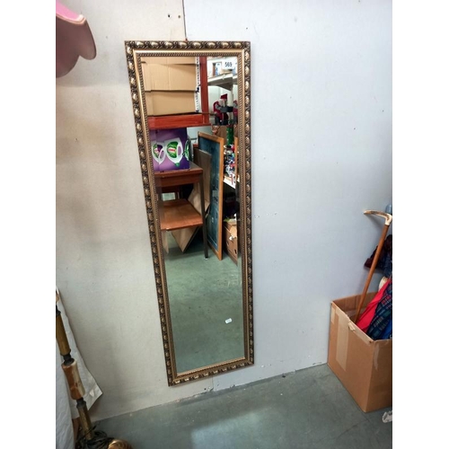569 - A gilt framed bevelled edge mirror. 37cm x 124cm. Collect Only.