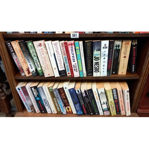 591 - A quantity of paperback books, including Bernard Cornwell and Peter May, etc.