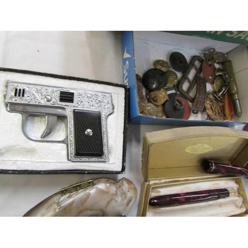 767 - A mixed lot including pistol lighter, fountain pen, badges, buttons etc.,