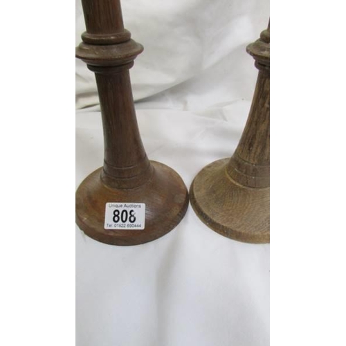 808 - A pair of wooden candle sticks.