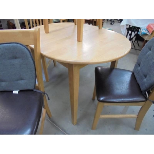 820 - A light oak extending dining table and four chairs.