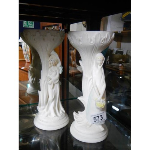 573 - A pair of figural pedestal ornaments.