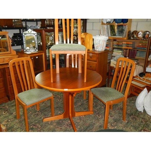 582 - A good clean teak extending dining table with four matching chairs.