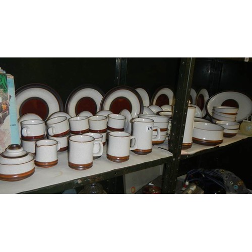 676 - Two shelves of Denby stoneware dinner ware.