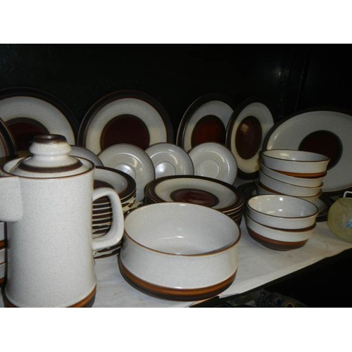 676 - Two shelves of Denby stoneware dinner ware.