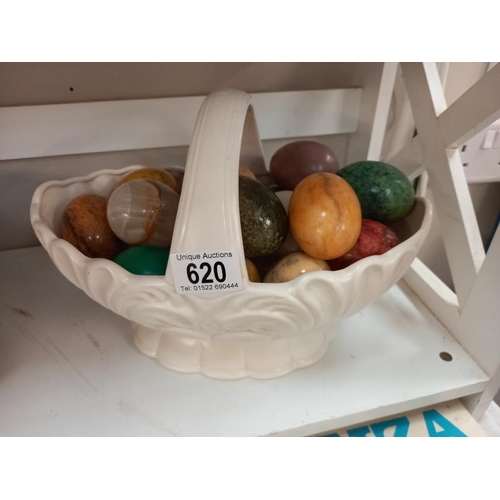 620 - A quantity of polished stone eggs in china basket