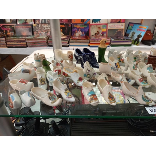 632 - A large selection of crested ware shoe ornaments