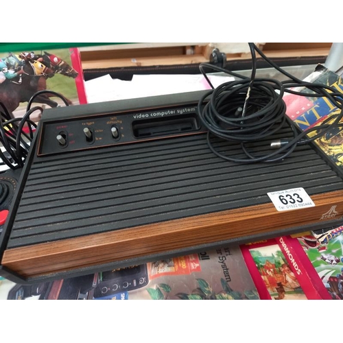 633 - A vintage Atari wood grain games console and selection of games and controls