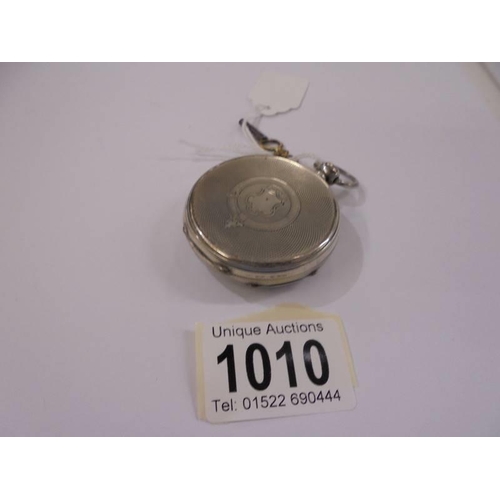 1010 - A silver pocket watch with key.