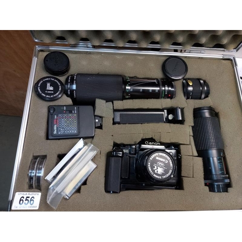 656 - A canon A1 1984 Olympic games 35mm camera with lenses and accessories in hard case. (chip in lens - ... 