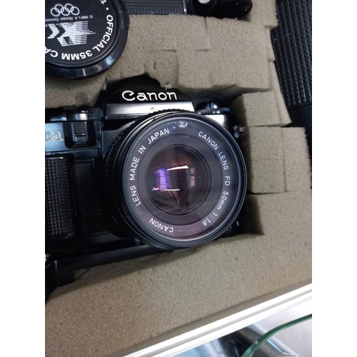 656 - A canon A1 1984 Olympic games 35mm camera with lenses and accessories in hard case. (chip in lens - ... 