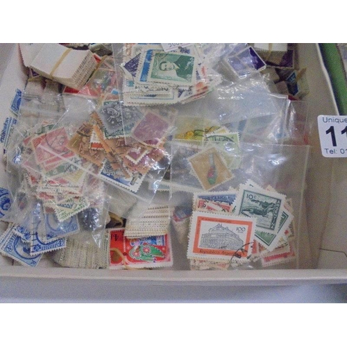 1180 - Two trays of assorted postage stamps.