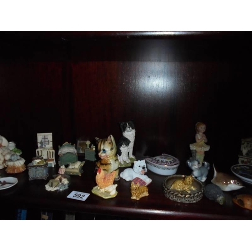 592 - Two shelves of assorted figures etc.,