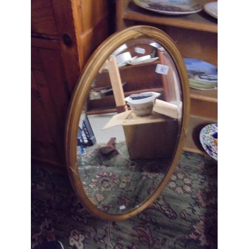 567 - An oval framed bevel edged mirror. COLLECT ONLY.