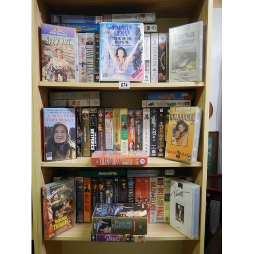 674 - Three shelves of assorted videos.