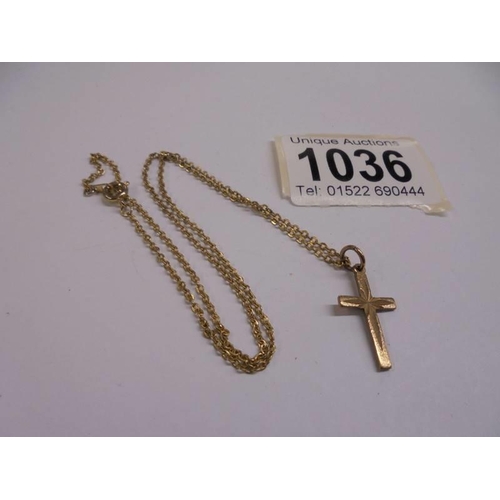 1036 - A 9ct gold cross on un-marked yellow metal chain.