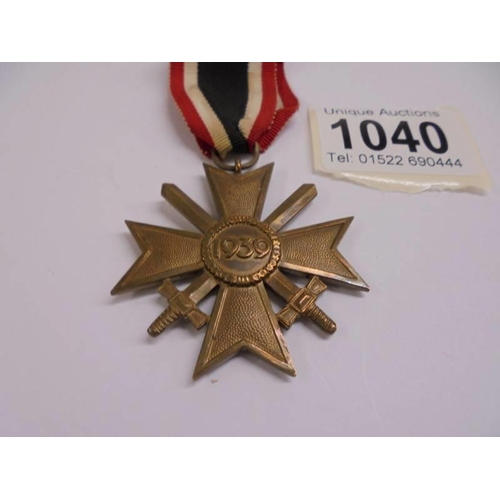 1040 - A German army war merit cross medal, post WW2 1957 pattern, crossed swords with ribbon bar.