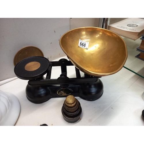 668 - A cast iron Salter kitchen scales with weights and brass pan