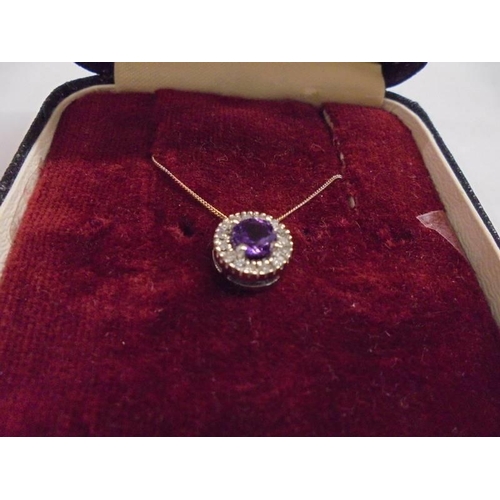 1052 - A diamond cluster pendant set with a centre amethyst in 9ct gold.