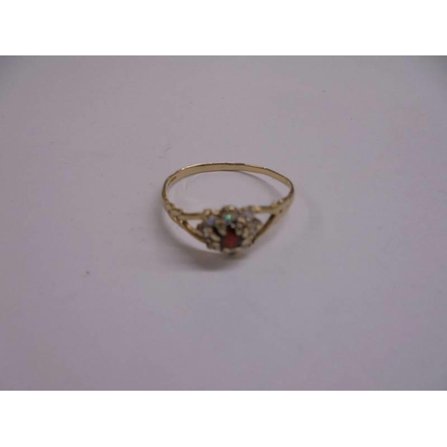 1056 - A white stone cluster ring with central red stone, dated 1993, hall marked,size O, 1 gram.