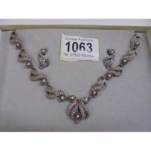 1063 - A suite of vintage jewellery comprising necklace, bracelet and earrings in white metal.