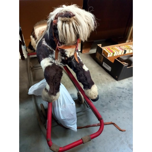 741 - A vintage straw filled rocking horse on folding wheels