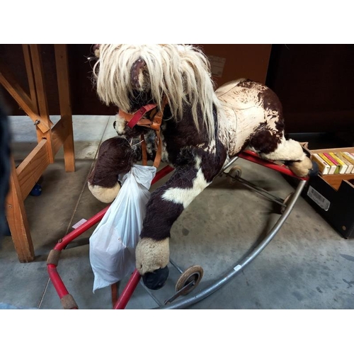 741 - A vintage straw filled rocking horse on folding wheels