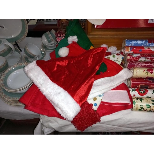 117 - A large lot quantity of miscellaneous Christmas items including hats, stockings, wreaths & wrapping ... 