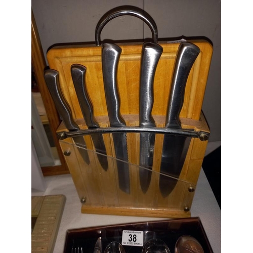 38 - A set of kitchen knives with chopping board and an 18 piece cutlery set