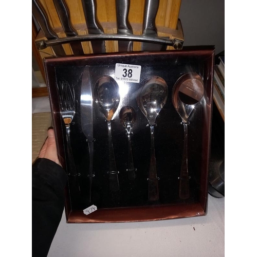 38 - A set of kitchen knives with chopping board and an 18 piece cutlery set