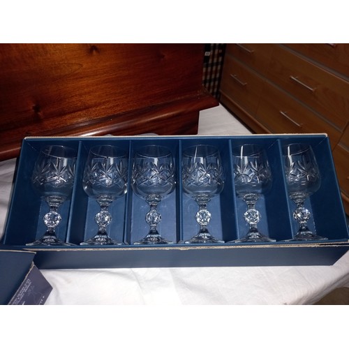 300A - A boxed set of 6 Bohemia cut glass wine glasses and a boxed set of 4 Cristal D'Arques cut glass wine... 