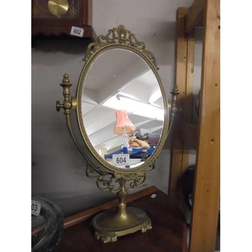 604 - An oval brass framed mirror.