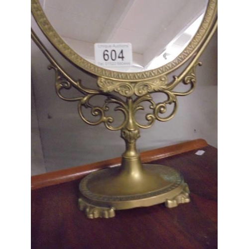 604 - An oval brass framed mirror.