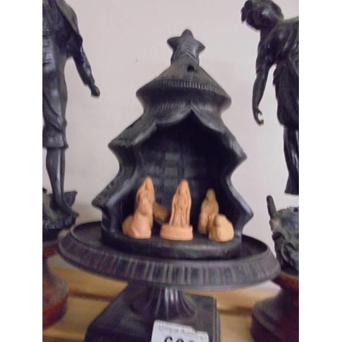 608 - A pair of figures and a nativity scene inside a Christmas tree.