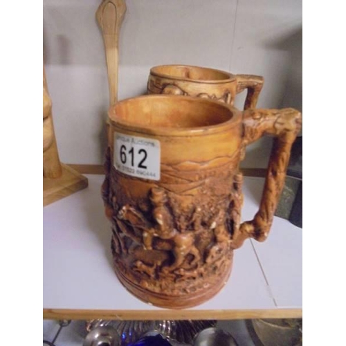 612 - Two carved wood birds, Two Scottish themed tankards and a wooden fork.