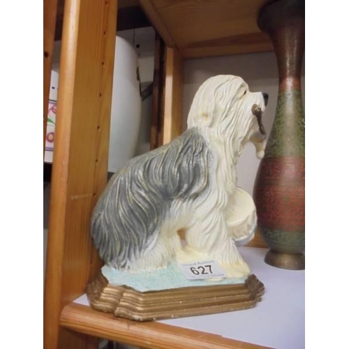 627 - A cast iron old English sheep dog door stop, a cast iron egg stand and a metal vase.