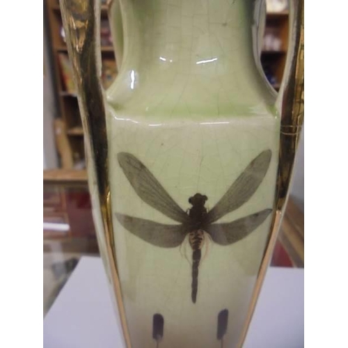 668 - A gilded ceramic vase decorated with dragon flies.