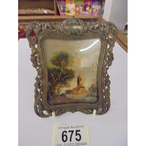 675 - A small painting in a metal frame, signed but indistinct.