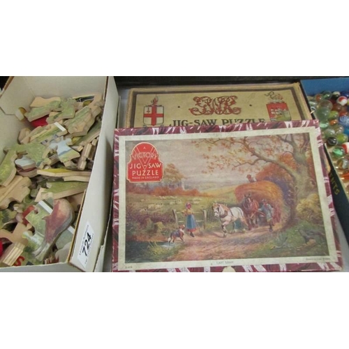 724 - A quantity of vintage jigsaw puzzles (completeness unknown) marbles etc.,