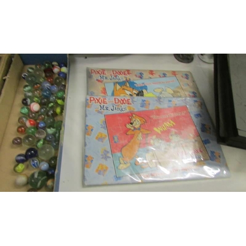 724 - A quantity of vintage jigsaw puzzles (completeness unknown) marbles etc.,