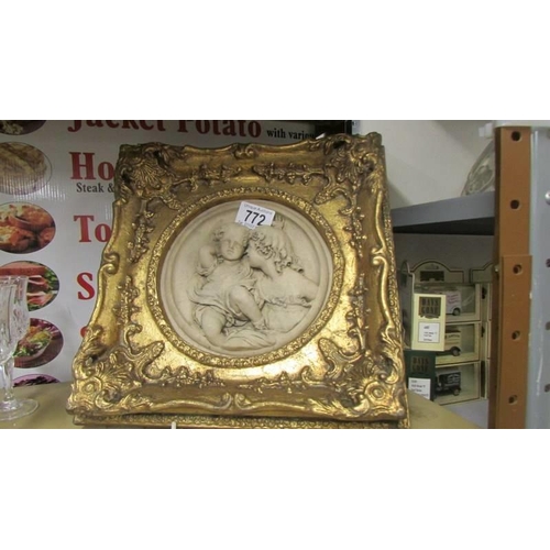 772 - A cherub plaque in a gilded frame.