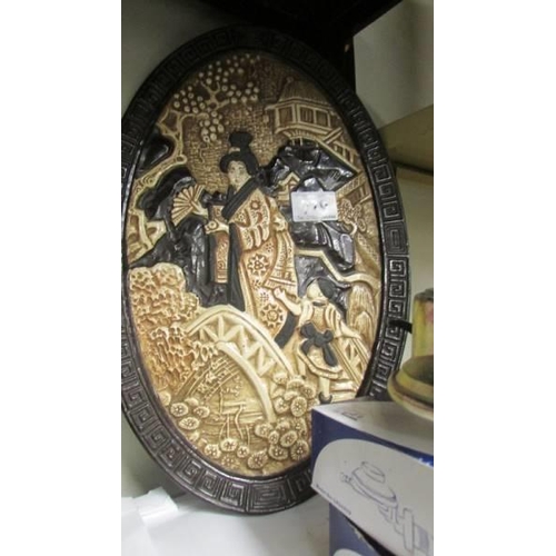 779 - An oval Japanese wall plaque.